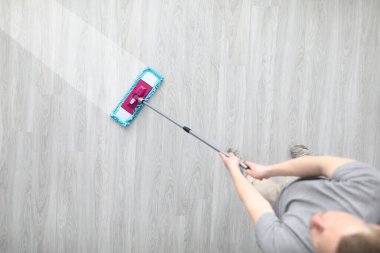 Erkek eli plastik paspası tutar ve kirli çamaşırları yıkar.