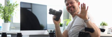 Male photographer sitting on wheelchair at table