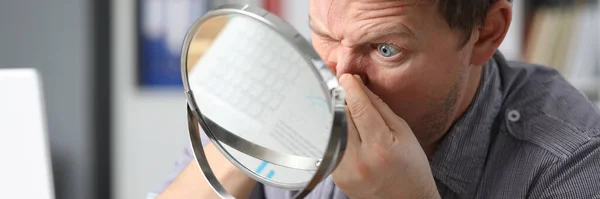 Man sits in front mirror and presses on his face — Stock fotografie