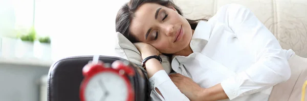 Girl sleeps after work couch, table an alarm clock — Stock Photo, Image