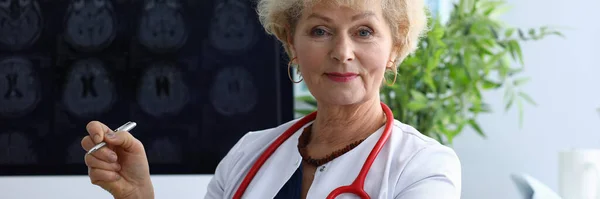 Доктор женщина держит ручку на заднем плане рентген — стоковое фото