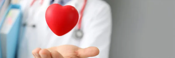 Доктор ловить серце, тримаючи папки руками — стокове фото