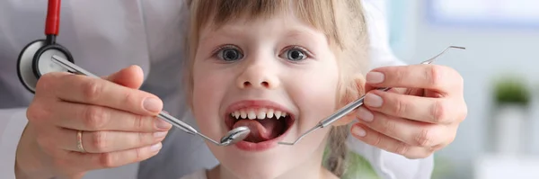Klein meisje is niet bang om tanden te laten zien aan tandarts — Stockfoto