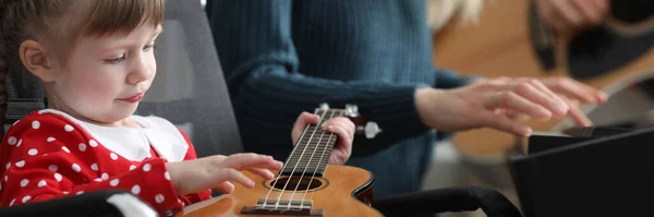 Os pais ensinam o bebê a tocar música ukulele juntos — Fotografia de Stock