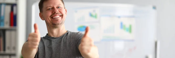 Chico feliz se para en la oficina y muestra buen gesto —  Fotos de Stock