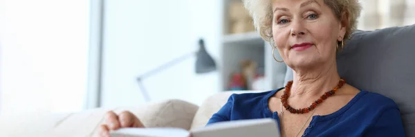 Пожилая женщина самоизоляция чтение книги дома — стоковое фото