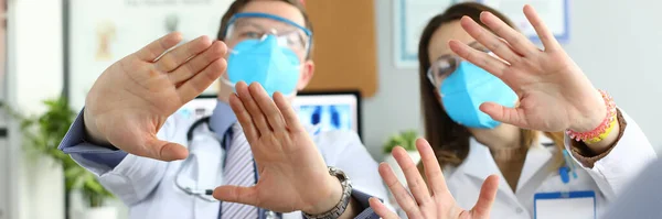 Vrouwelijke en mannelijke artsen onderzochten beschermende maskers — Stockfoto