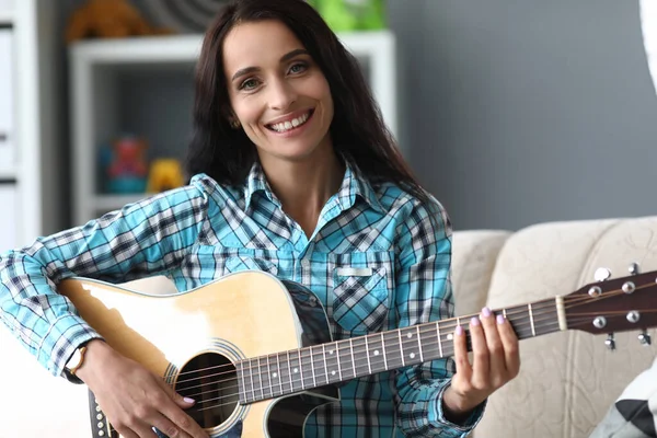 快乐的年轻女子在家弹吉他 — 图库照片