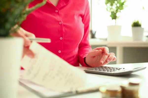 Female office worker using calculator at work — Stock Photo, Image