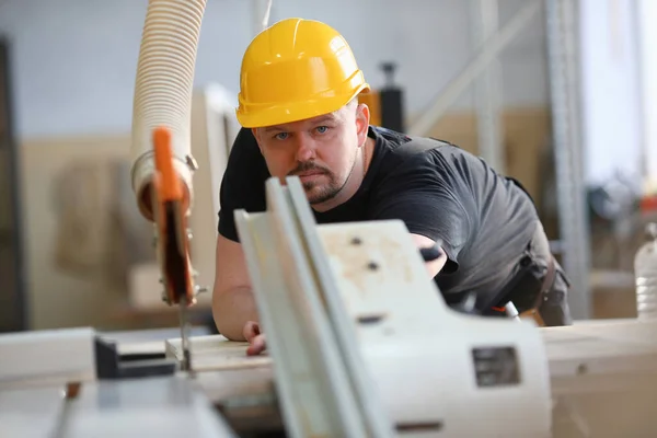 Mannelijke werknemer met behulp van elektrische zaag op timmerwerk — Stockfoto
