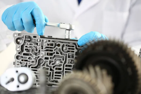 Joven manos reparando piezas de la caja de cambios del coche — Foto de Stock