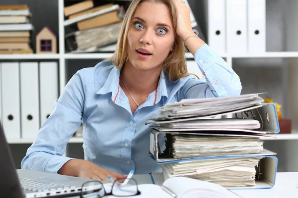 Verbaasde jonge vrouw met veel werk in het kantoor — Stockfoto