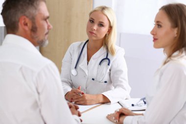 Güzel bayan doktor iş arkadaşlarıyla konuşuyor.
