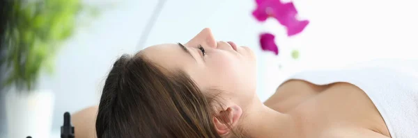 Menina encontra-se em sala de massagem, perto de óleos aromáticos — Fotografia de Stock