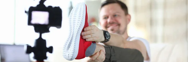 Man raised his leg and shows sneaker to camera