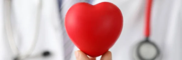 Doktor sahte kalbi siyah noktayla tutuyor, kalp pili. — Stok fotoğraf