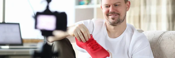 Guy cámara frontal en el apartamento muestra nuevas zapatillas —  Fotos de Stock