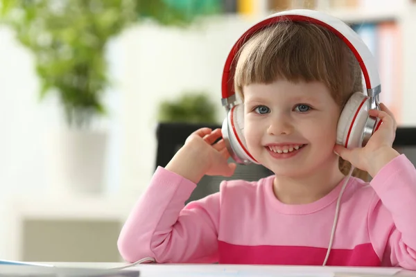 Criança feliz usando fones durante a aula — Fotografia de Stock