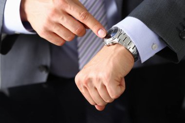 İş adamı kol saatini kontrol ediyor.