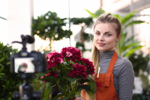 Beautiful smiling young florist in flower shop — Stock Photo, Image