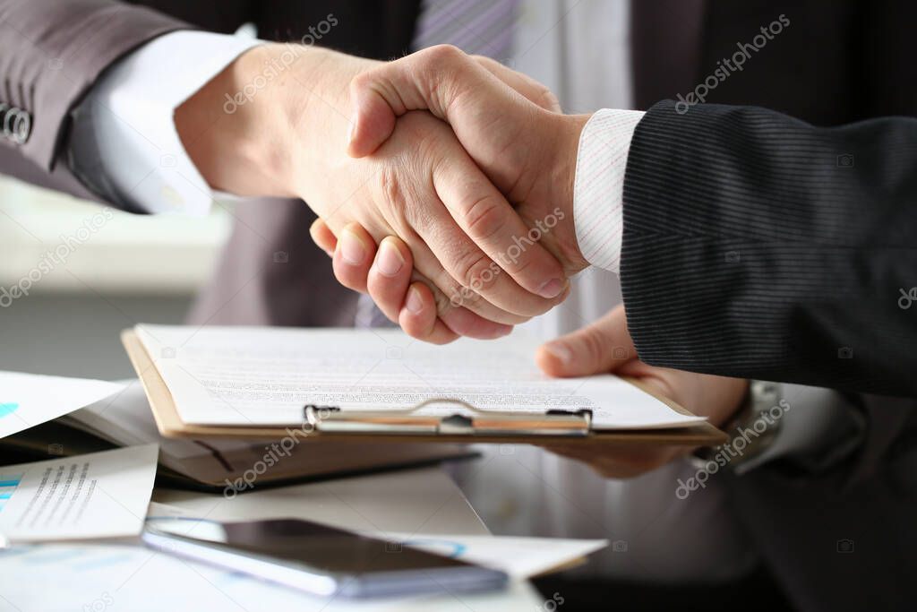 Two men are shaking hands in office