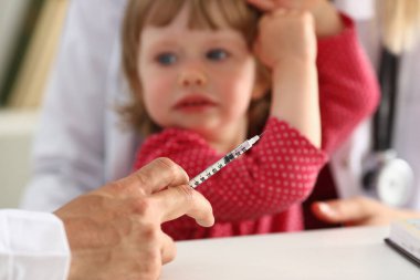 Küçük çocuk aşıdan önce doktora bakmaya korkuyor.