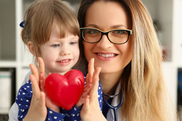 Vacker vuxen kvinnlig läkare med liten flicka på kliniken — Stockfoto