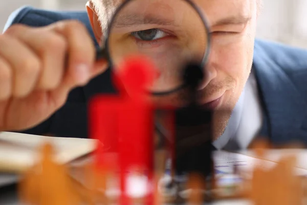 Mann im Anzug hält Lupe am Arbeitsplatz — Stockfoto