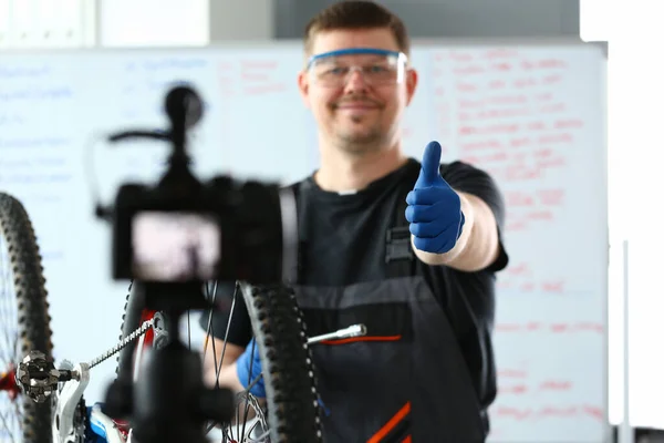 Uomo sorridente in occhiali di sicurezza che fa video adout bike — Foto Stock