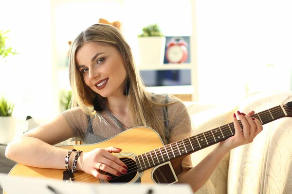 Sorrindo jovem loira tocando guitarra acústica — Fotografia de Stock