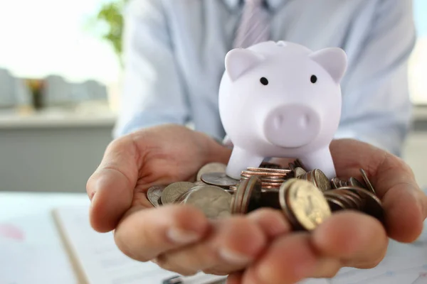 Male hands holding metal coin and piggy bank — Stock Photo, Image