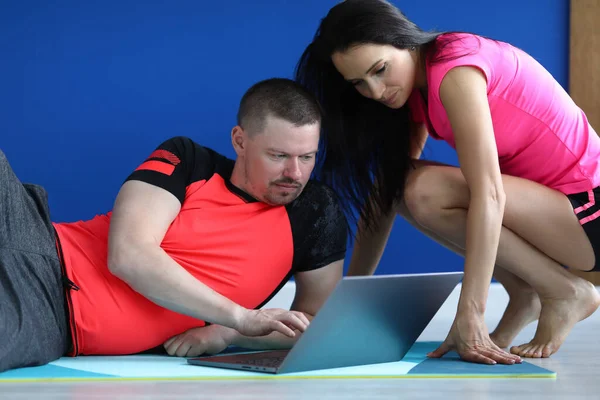 Treinador mostra exercícios para estudante no laptop . — Fotografia de Stock