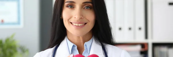 Piękny uśmiechnięty lekarz trzymający w rękach czerwone serce zabawki — Zdjęcie stockowe