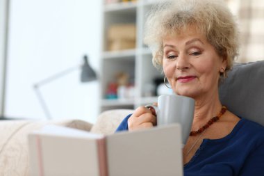 Kanepede oturan sarışın yaşlı bayan.