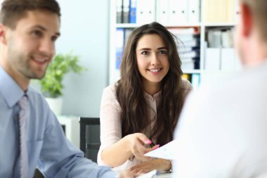 Ofiste buluşurken üç meslektaşına gülümsemek.