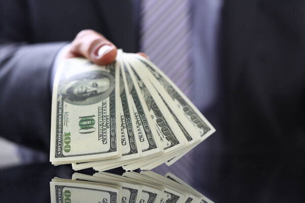 Rich businessman demonstrating bunch of banknotes in hand
