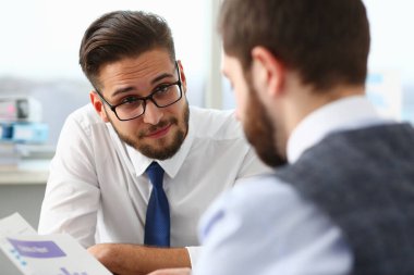 İki yönetici ofiste iş meselelerini tartışıyor.
