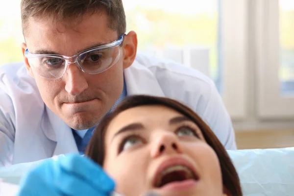 Ung kvinna under möte med tandläkare på kliniken — Stockfoto