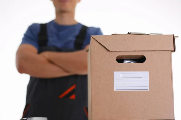 Man in working apron bringing parcel in cardboard — Stock Photo, Image