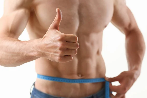 Deportista bien formado midiendo su abdomen con cinta centímetro — Foto de Stock