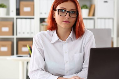 Ofiste defter üzerinde çalışan sakin kırmızı kadın.