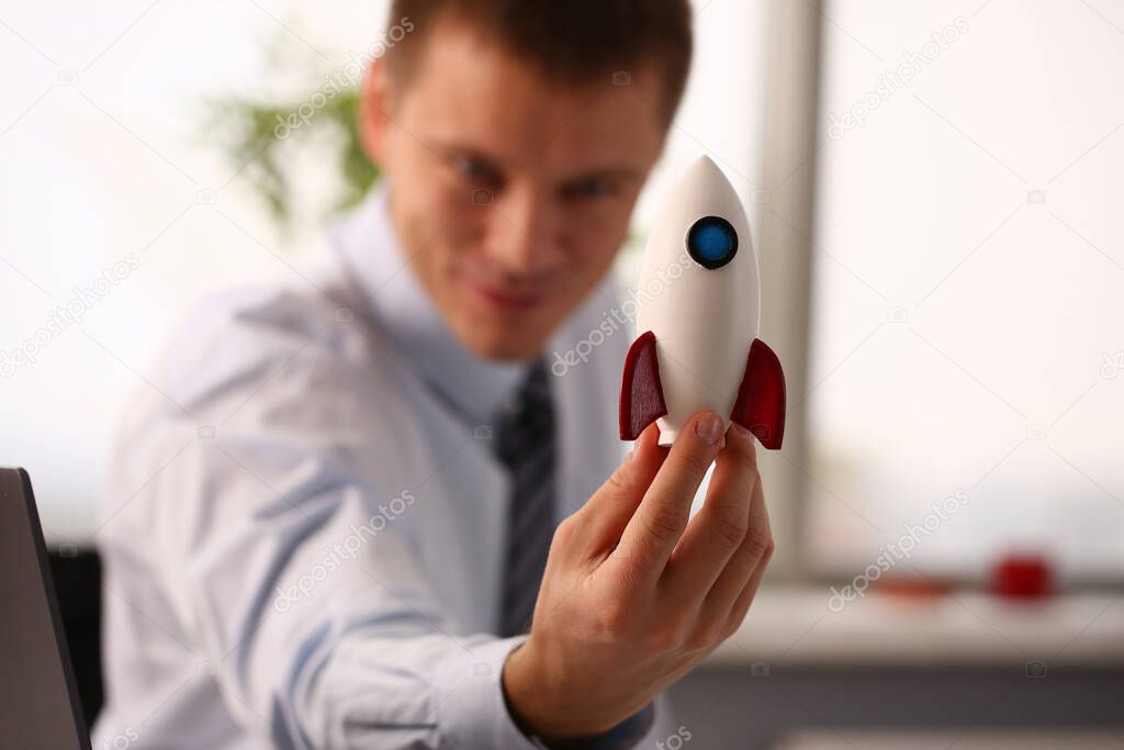 Cheerful manager holding plastic missile in office