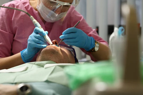 Koncentrerad ung tandläkare gör tandkontroll på kliniken — Stockfoto