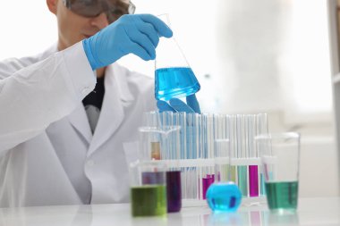 Uzman araştırmacı elinde ayırıcıyla mataraya bakıyor.