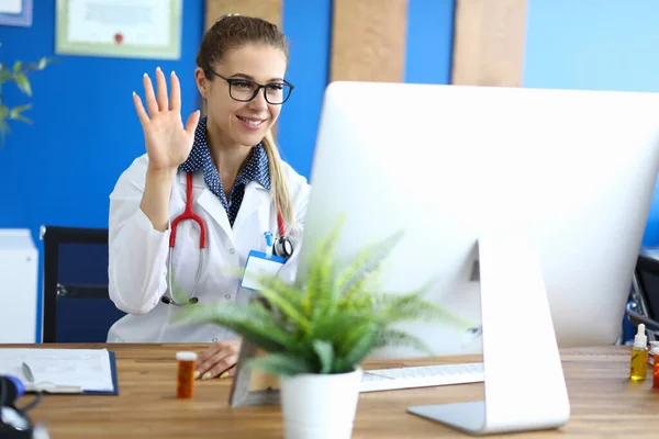 Mujer sonriente médico da la bienvenida a la paciente en línea —  Fotos de Stock