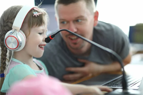 Menina em fones de ouvido aprender a trabalhar no laptop — Fotografia de Stock