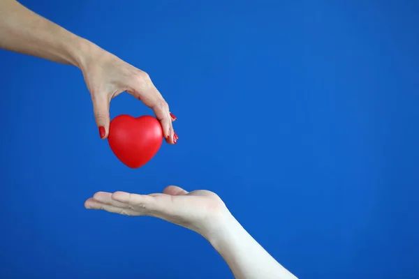 Mãos passam coração vermelho conceito de doença cardíaca — Fotografia de Stock