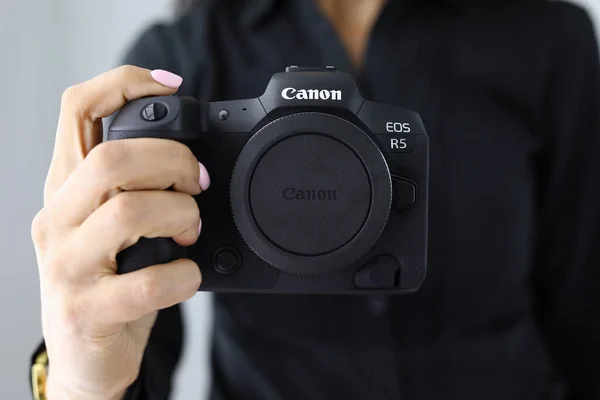 Mujer sostener nuevo modelo canon EOS R5 cámara en mano primer plano —  Fotos de Stock