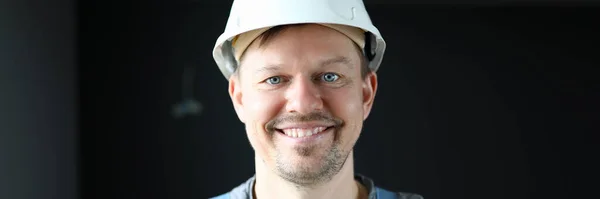 Seorang pria dalam pakaian kerja memakai helm pelindung tersenyum — Stok Foto