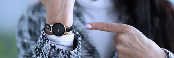 Displeased woman shows time on her wristwatch — Stock Photo, Image